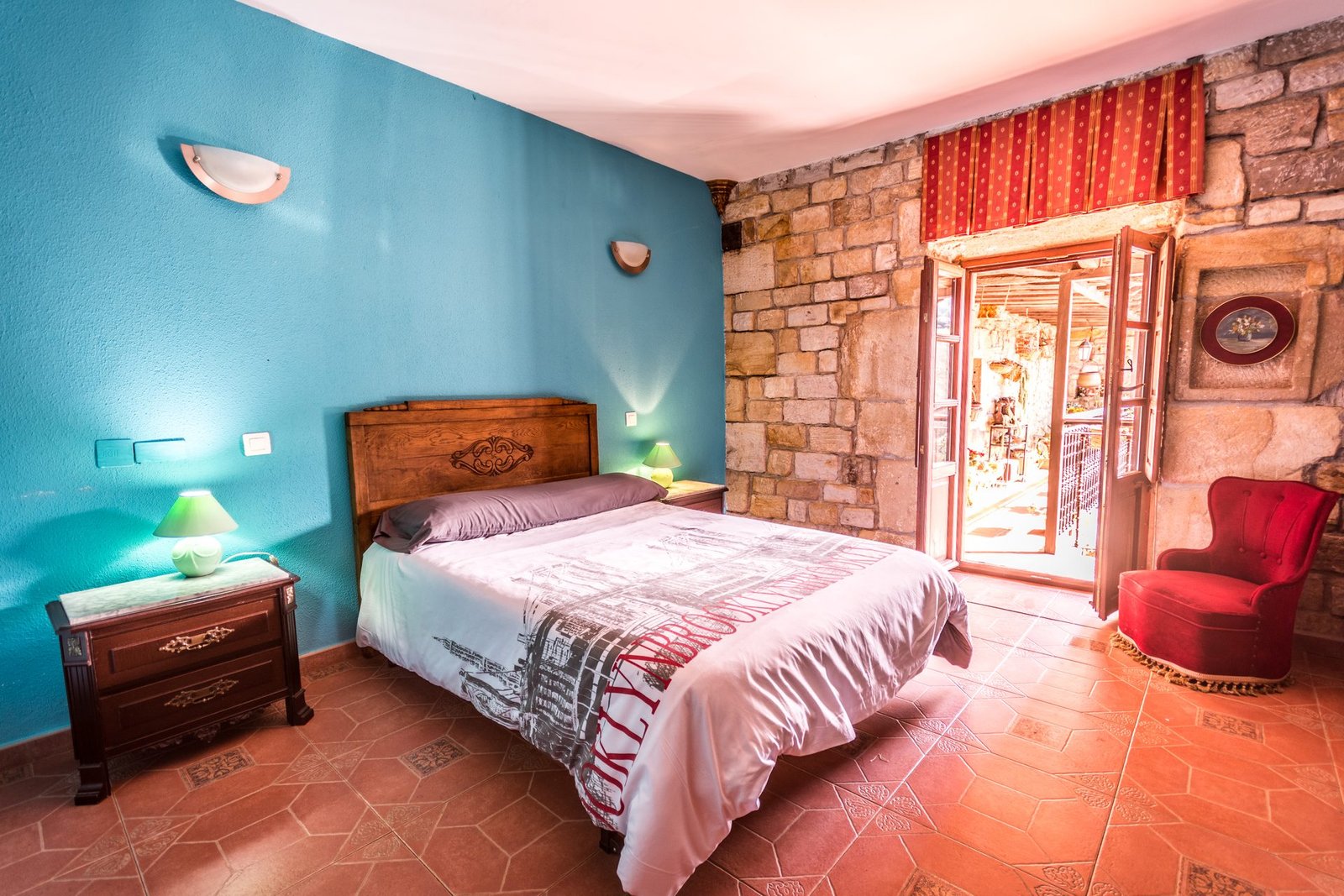 Habitación doble con pared de piedra y balcón en Finca Gándara